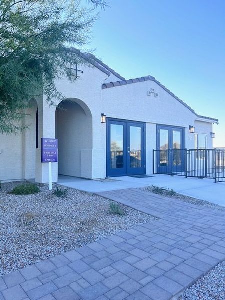 A charming home with arched entry, sleek windows, and desert landscaping in The Vistas Collection at Village at Sundance by Century Communities (Buckeye, AZ).