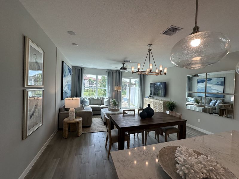 A contemporary living room with wooden flooring, a cozy sectional sofa, and elegant lighting.