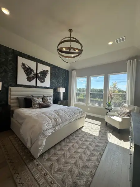 A chic bedroom with a plush bed, modern lighting, and large windows offering natural light and scenic views. A chic bedroom with a plush bed, modern lighting, and large windows offering natural light and scenic views.
