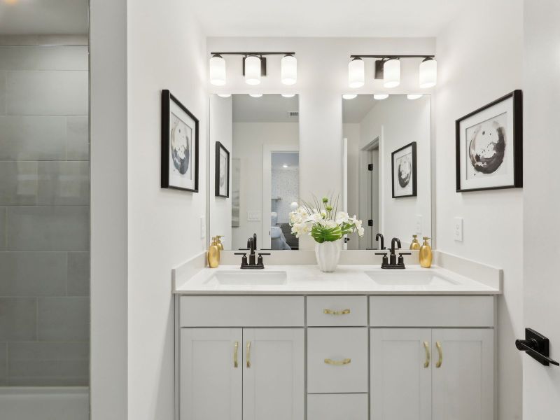 The primary bathroom offers dual vanity sinks and a walk-in shower.