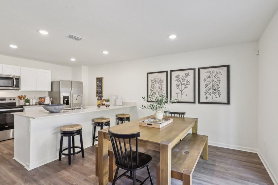 A kitchen with a table and chairs.