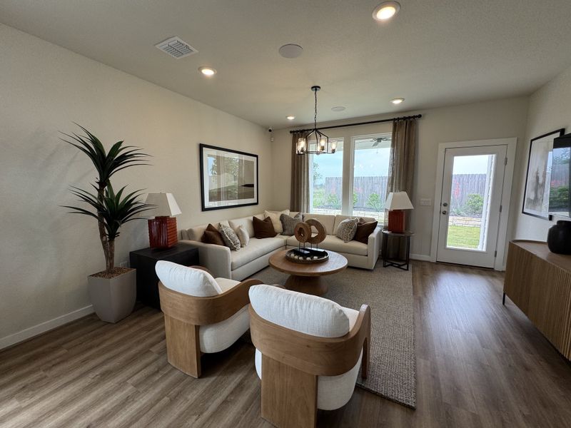 A cozy living room with wood floors, a cream sectional, modern chairs, and warm lighting accents a neutral palette. A cozy living room with wood floors, a cream sectional, modern chairs, and warm lighting accents a neutral palette.