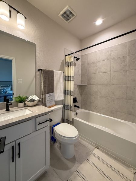 A modern bathroom with elegant tiles, a sleek vanity, and stylish lighting for a fresh, contemporary look.