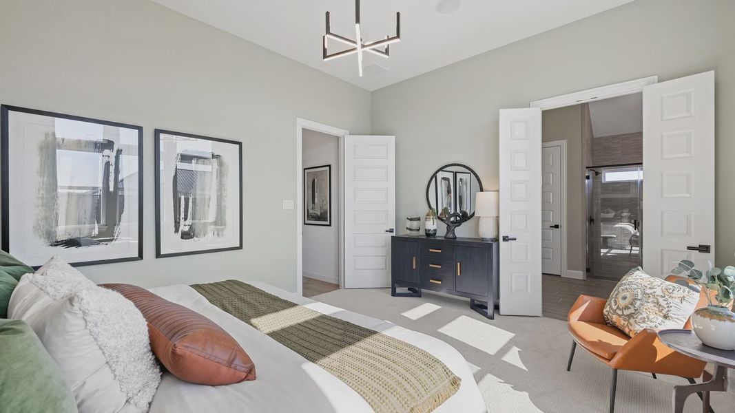 Southern Pointe bedroom boasts refined French doors and a statement chandelier, exuding ultimate sophistication.