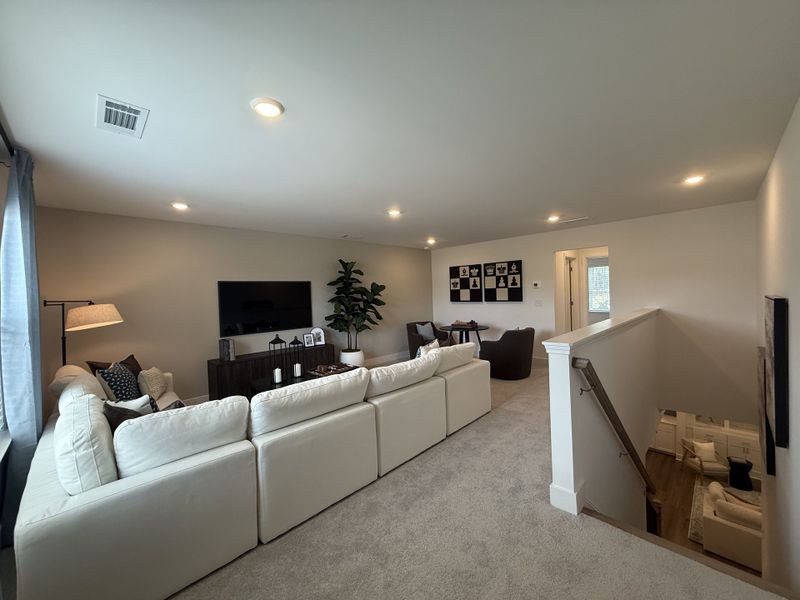 A cozy loft living area with a plush sectional, stylish decor, and abundant natural light. Perfect for relaxation and entertainment.