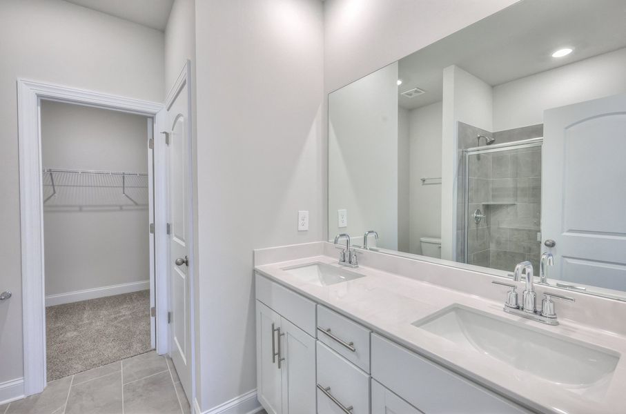 The primary bathroom offers dual vanity sinks and a walk-in closet.