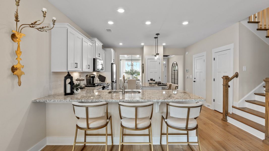 Exclusive kitchen design with a center island, pendant lights, and tasteful finishes throughout by DRB Homes