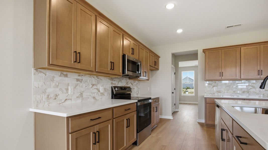 Lassiter plan kitchen with quartz countertops and tile backsplash Lassiter plan kitchen with quartz countertops and tile backsplash