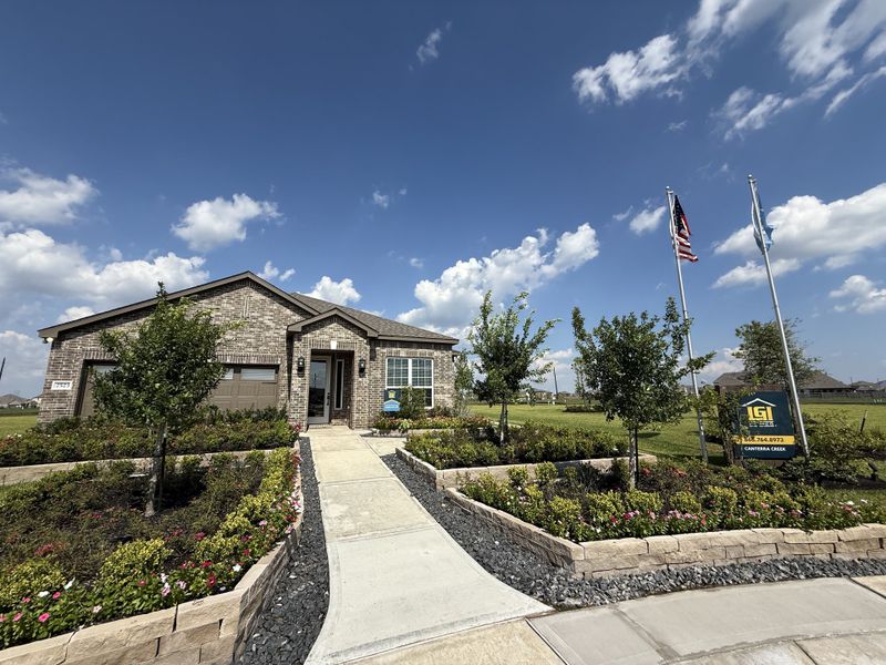 A charming brick home with lush landscaping in the Canterra Creek neighborhood by LGI Homes (Arcola, TX).