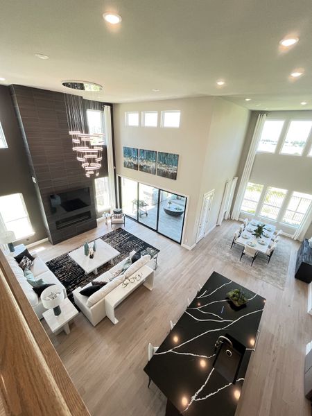 A spacious living area with modern decor, sleek lighting, and an elegant black kitchen island overlooking a bright dining space. A spacious living area with modern decor, sleek lighting, and an elegant black kitchen island overlooking a bright dining space.