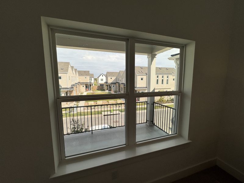 A bright room window overlooks a charming suburban street, showcasing a neighborhood of elegant homes. A bright room window overlooks a charming suburban street, showcasing a neighborhood of elegant homes.