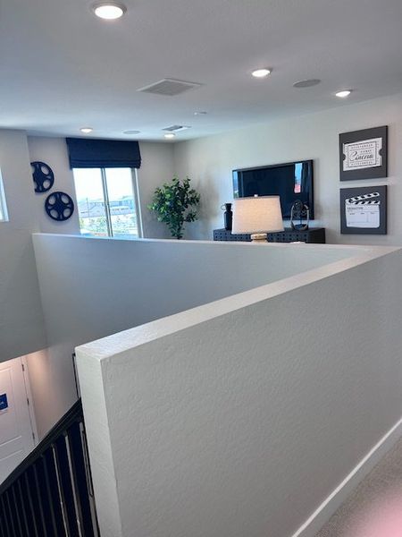 A contemporary upstairs loft with stylish decor, media accents, and abundant natural light.