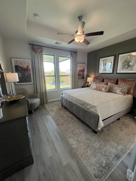A cozy bedroom featuring soft lighting, elegant wall art, and a plush bed with a neutral palette. Light floods through large windows. A cozy bedroom featuring soft lighting, elegant wall art, and a plush bed with a neutral palette. Light floods through large windows.