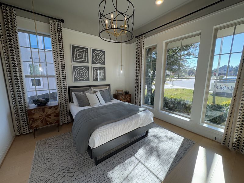 A cozy bedroom featuring a modern chandelier, geometric art, and large windows with elegant drapes. A cozy bedroom featuring a modern chandelier, geometric art, and large windows with elegant drapes.