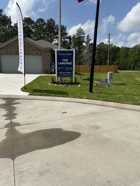 A welcoming brick home with a manicured lawn in The Landing by K. Hovnanian® Homes (New Caney, TX).