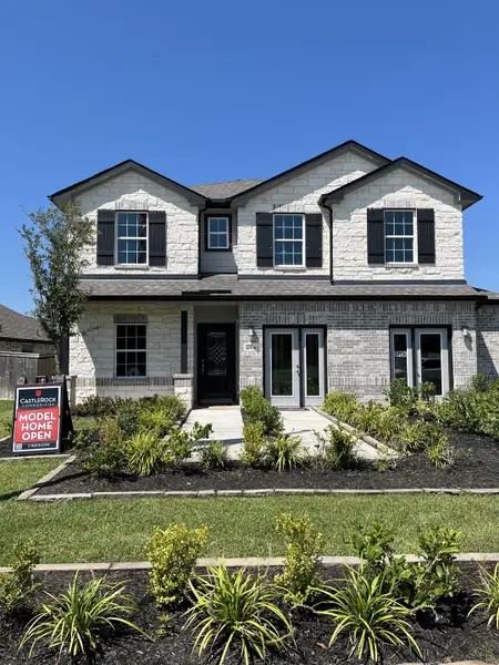 Elegant home with black shutters and a manicured yard in Massey Oaks by CastleRock Communities (Pearland, TX).