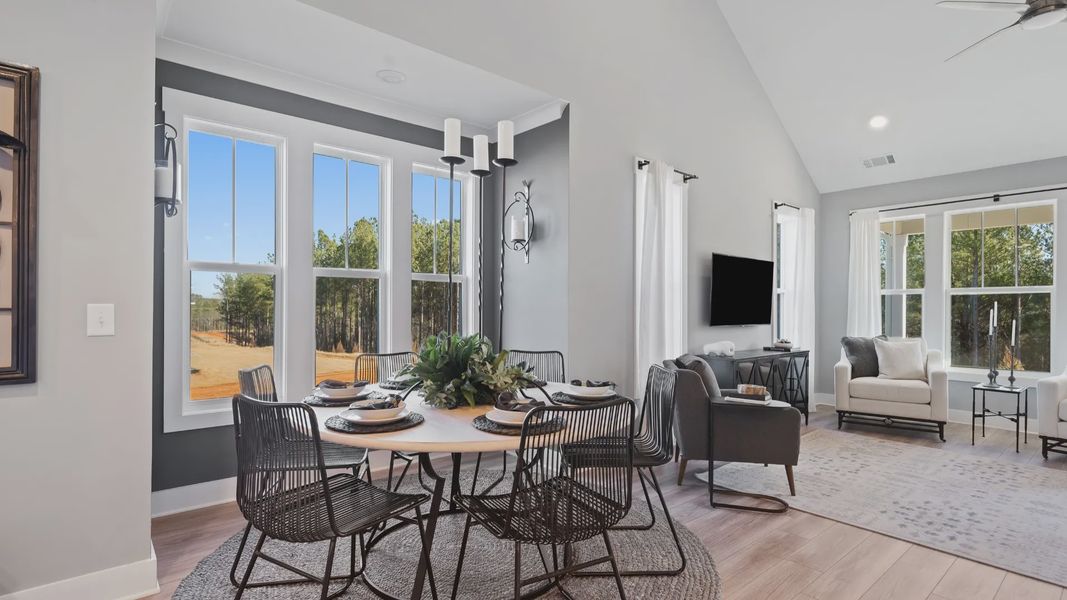 Breakfast area of the Lakehurst floorplan featuring 2 story ceiling, large windows and LVP flooring at Village at Midway Breakfast area of the Lakehurst floorplan featuring 2 story ceiling, large windows and LVP flooring at Village at Midway