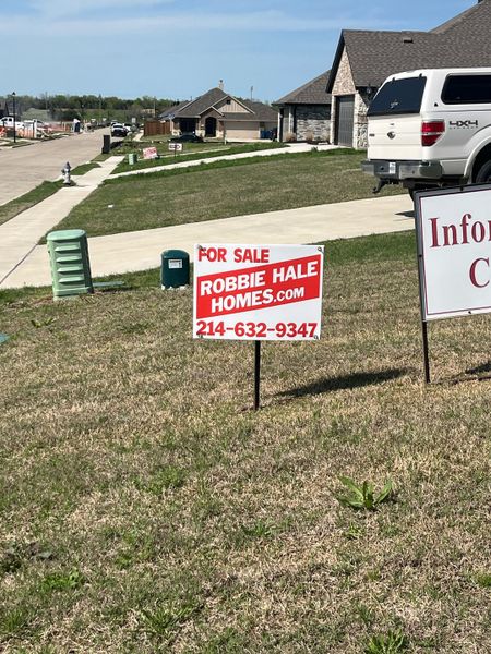 A charming suburban street with new homes in High Meadows Estates by Robbie Hale Homes (Nevada, TX).