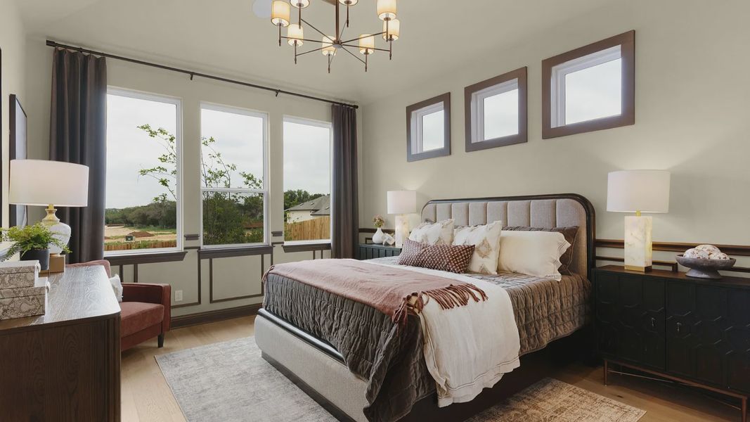 Owner’s suite with abundant natural light, woodwork details, and warm-toned flooring for a refined feel.
