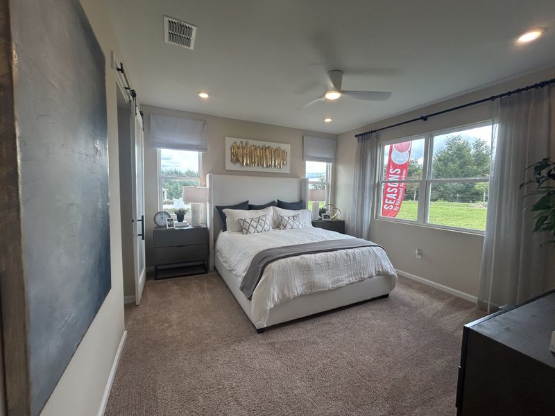 A cozy bedroom with a plush carpet, modern bed, and large windows letting in natural light, creating a serene ambiance. A cozy bedroom with a plush carpet, modern bed, and large windows letting in natural light, creating a serene ambiance.