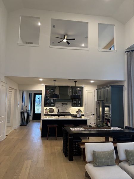 A contemporary open-floor kitchen with sleek cabinets, an island, and dining area, under a vaulted ceiling with modern decor. A contemporary open-floor kitchen with sleek cabinets, an island, and dining area, under a vaulted ceiling with modern decor.