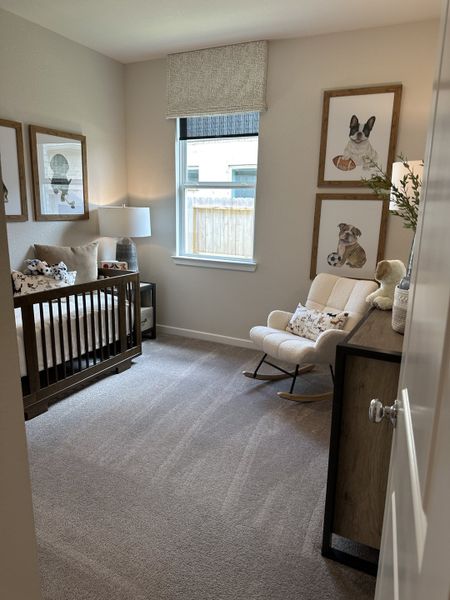 A cozy nursery with soft carpeting, wooden crib, plush rocking chair, and charming animal art on the walls. A cozy nursery with soft carpeting, wooden crib, plush rocking chair, and charming animal art on the walls.