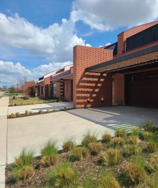 Contemporary red brick homes with modern landscaping in Tapestry by Total Environment Homes (Frisco, TX). Contemporary red brick homes with modern landscaping in Tapestry by Total Environment Homes (Frisco, TX).