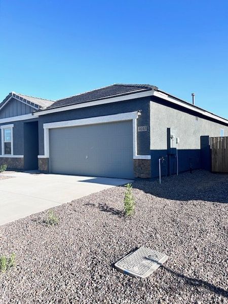 A contemporary gray home with stone accents in Bella Vista Farms by Starlight Homes, San Tan Valley, AZ.
