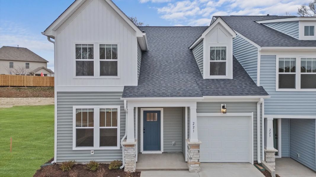Grey and white siding end unit with dark blue door, two car driveway with one car garage, and stone detail in Lyman, SC Grey and white siding end unit with dark blue door, two car driveway with one car garage, and stone detail in Lyman, SC