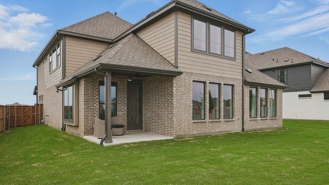 Elegant brick facade with expansive windows in Westridge showcases luxury living with a spacious backyard.