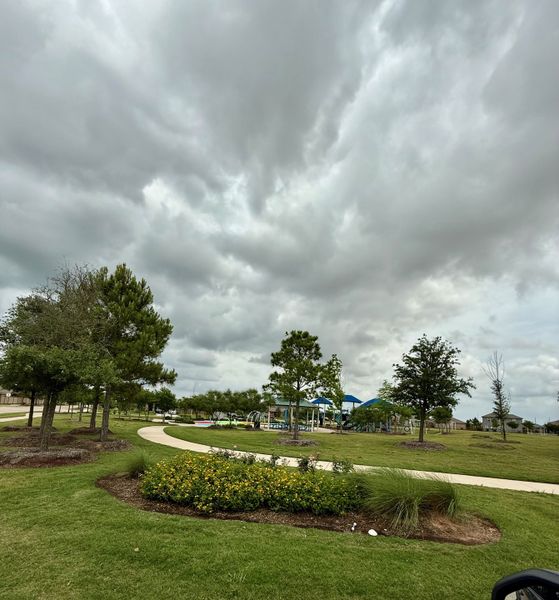 A scenic park with walking paths and lush greenery in Freeman Ranch by LGI Homes (Katy, TX).