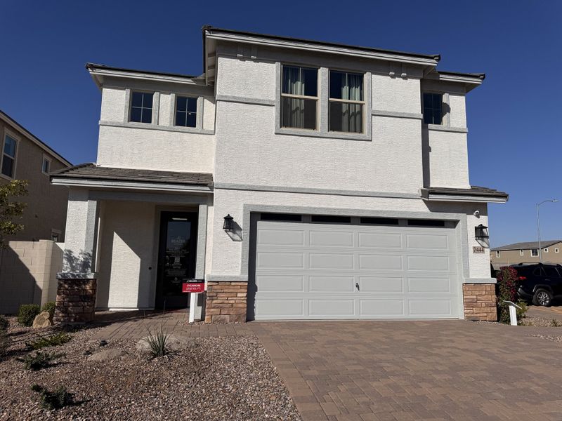 A modern white stucco home with stone accents and a spacious driveway in Bethany Grove by Beazer Homes (Glendale, AZ).