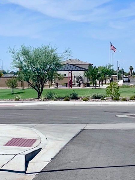 A scenic community park with greenery and an American flag in Seasons at Laveen Vistas by Richmond American Homes (Phoenix, AZ).