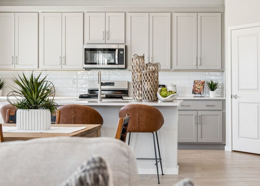 A kitchen with white cabinets.