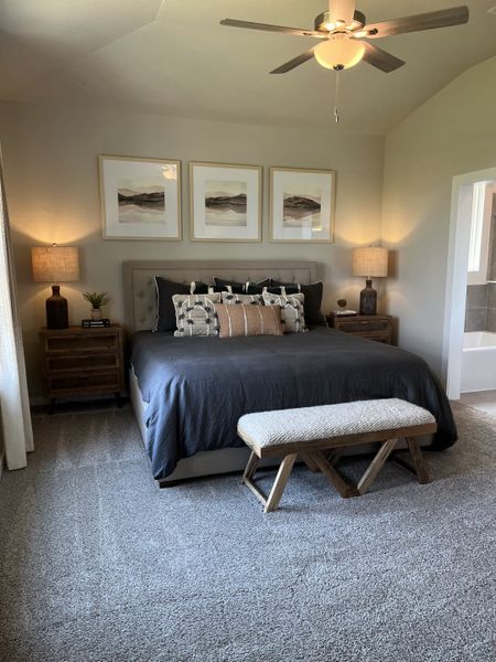 A cozy bedroom featuring a plush bed, wooden nightstands, elegant wall art, and soft lighting, perfect for relaxation.