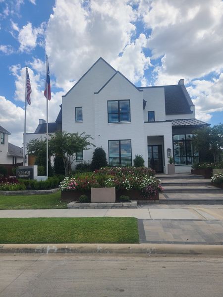 A charming white brick home with lush landscaping in Mosaic: 70ft. lots by Highland Homes (Celina, TX).