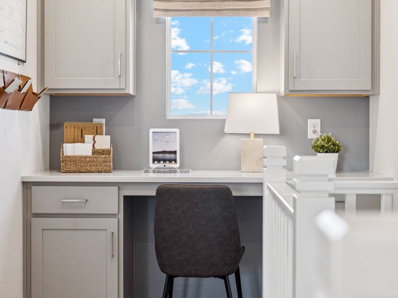 A white kitchen with a black chair.