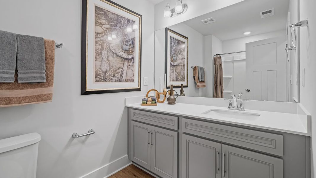 Elevated secondary bathroom with large vanity, gray cabinetry, and polished nickel finishes at Aspen Ridge Elevated secondary bathroom with large vanity, gray cabinetry, and polished nickel finishes at Aspen Ridge