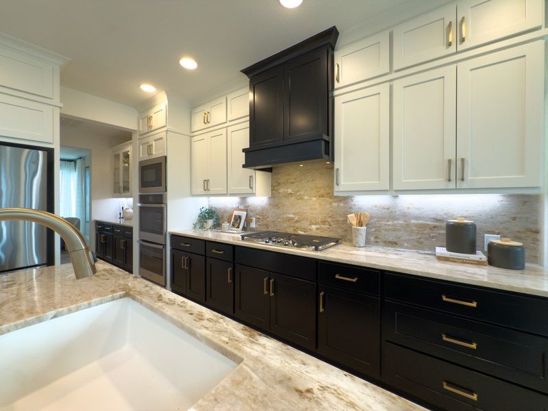 A modern kitchen with elegant black and white cabinetry, sleek countertops, and stainless steel appliances. A modern kitchen with elegant black and white cabinetry, sleek countertops, and stainless steel appliances.