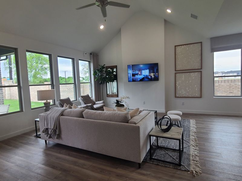 A cozy living room with a plush sectional, sleek hardwood floors, large windows, and modern decor. A cozy living room with a plush sectional, sleek hardwood floors, large windows, and modern decor.
