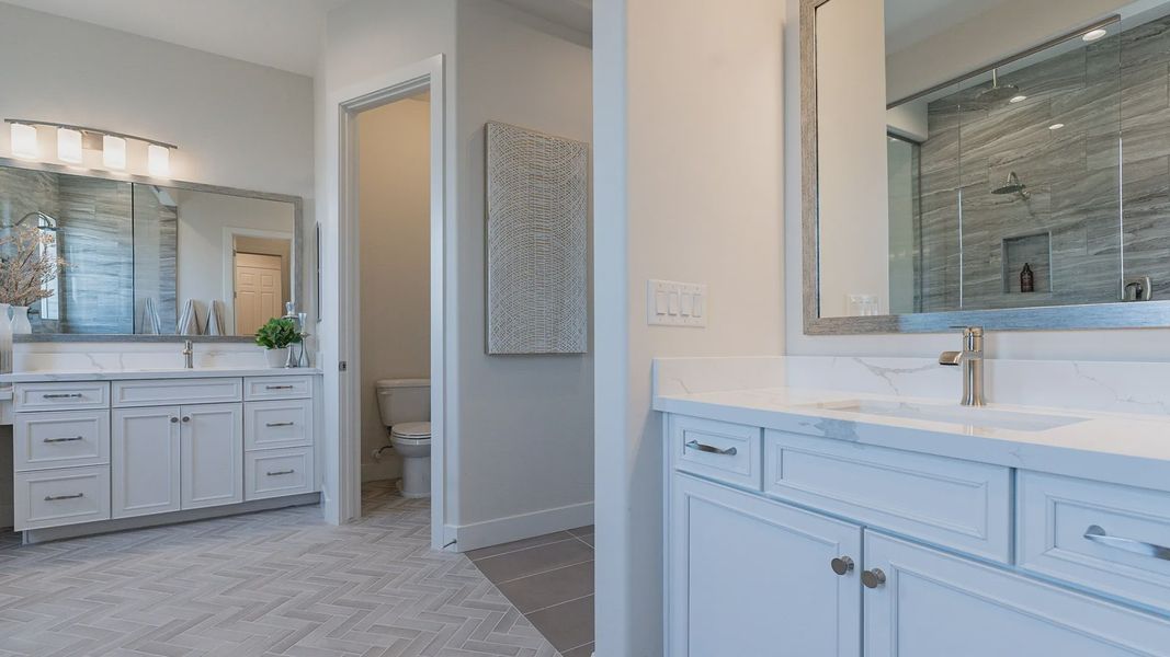 Exquisite dual vanities, marble countertops, and elegant lighting in Windrose community offer refined luxury.
