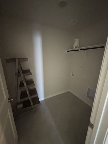 A cozy, minimalist space featuring neutral walls, tiled flooring, and rustic wooden shelves.