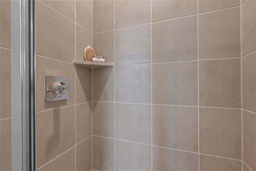 A shower with a shelf and a basket on it. A shower with a shelf and a basket on it.