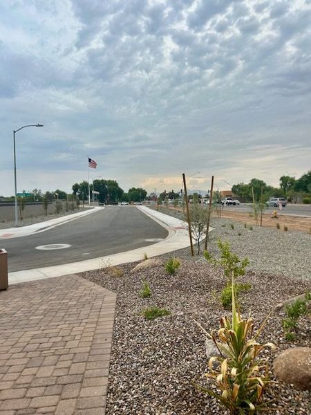 A picturesque road through Bethany Grove by Beazer Homes in Glendale, AZ, featuring landscaped paths and tranquil surroundings.