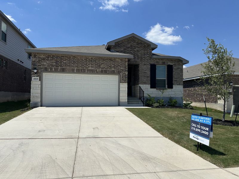 A modern brick home with garage and manicured lawn in Comanche Ridge by Meritage Homes (San Antonio, TX).