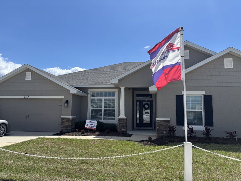 A charming modern home with stone accents and well-maintained landscaping in Brookhaven by Adams Homes (Ocala, FL).