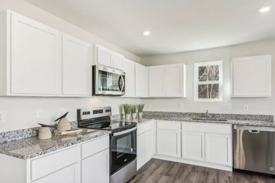 A kitchen with white cabinets.