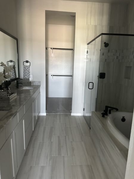 A modern bathroom with a sleek vanity, spacious shower, and elegant tiling, offering a serene retreat.