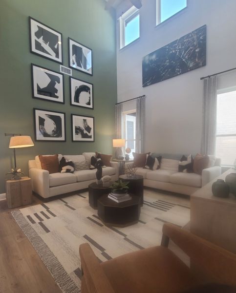 A modern living room with high ceilings, abstract art, cozy sofas, and stylish decor.
