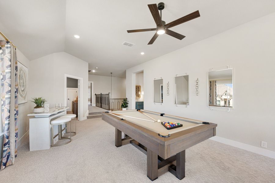 Game room with pool table, vaulted ceiling, ceiling fan, and small bar area on carpet flooring